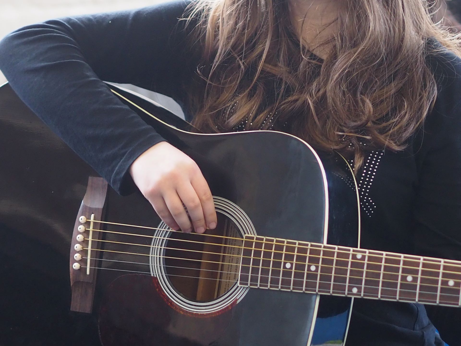 Close up of a guitar and someone playing it