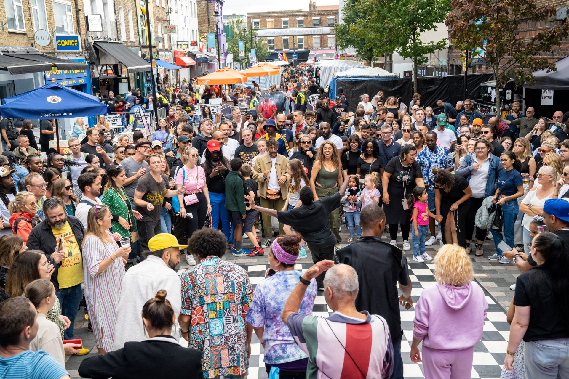 People gathering round a performer at a festival