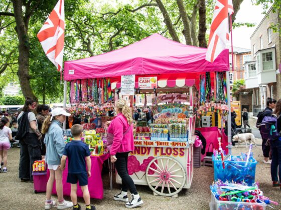 A family standing by a pink candy floss stall