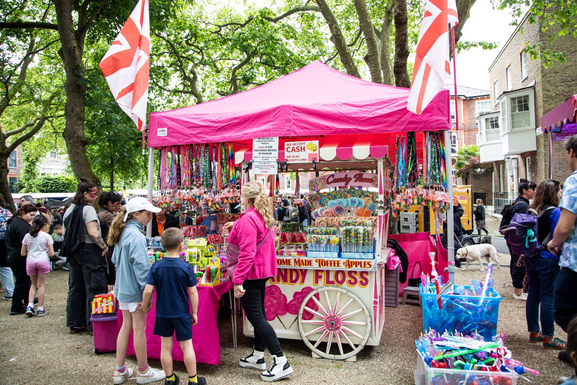 A family standing by a pink candy floss stall