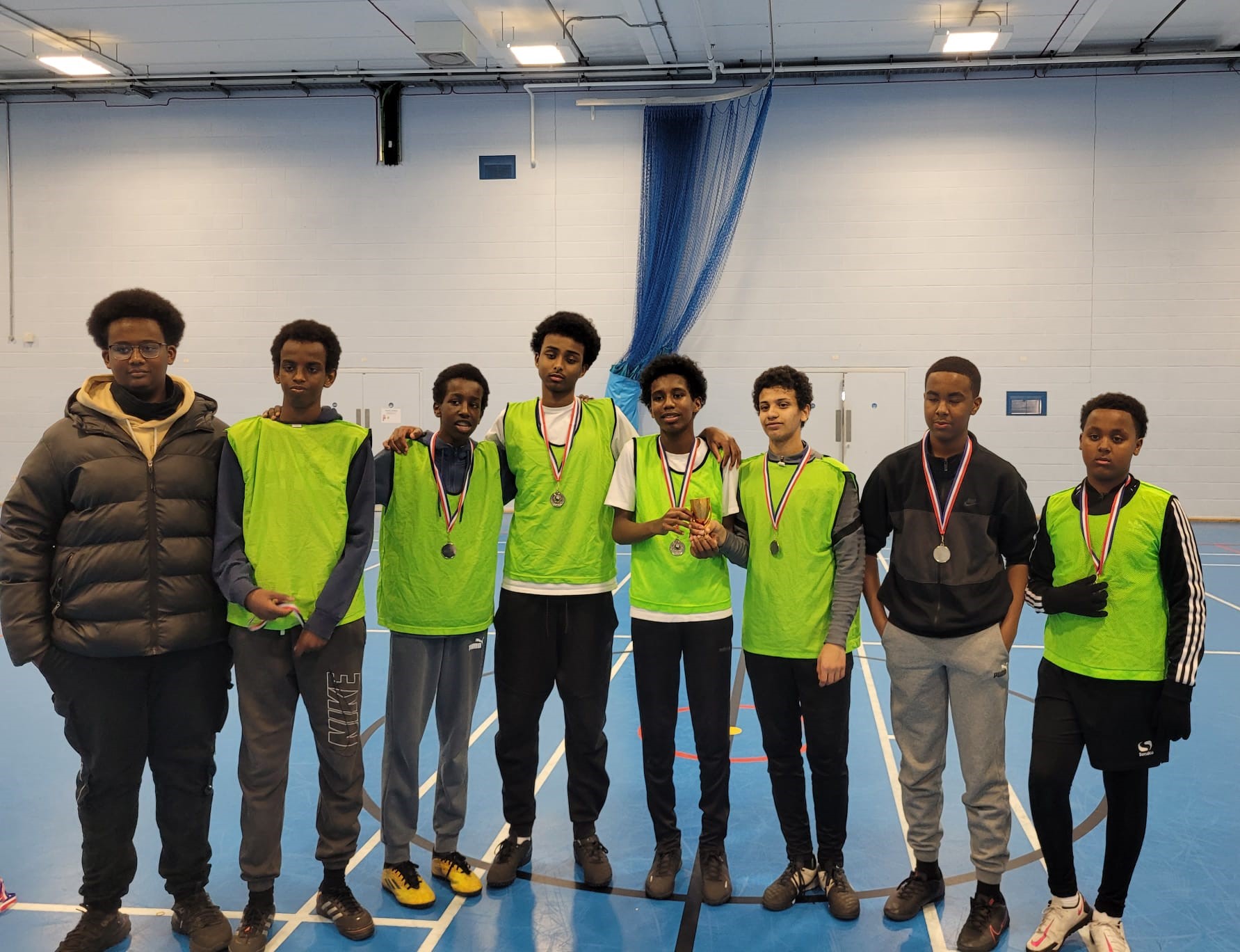 boys wearing medals in sports hall