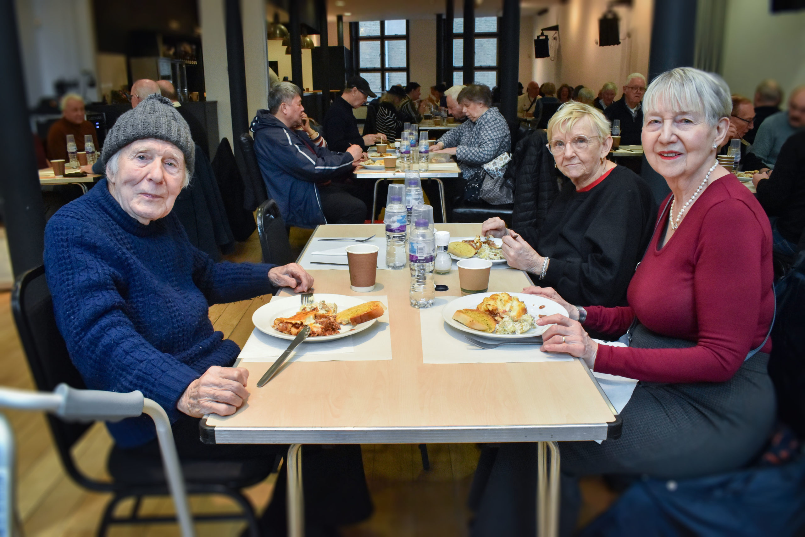 A man and two women enjoy their meals at the over 50s lunch club hosted by the Covent Garden Community Centre.